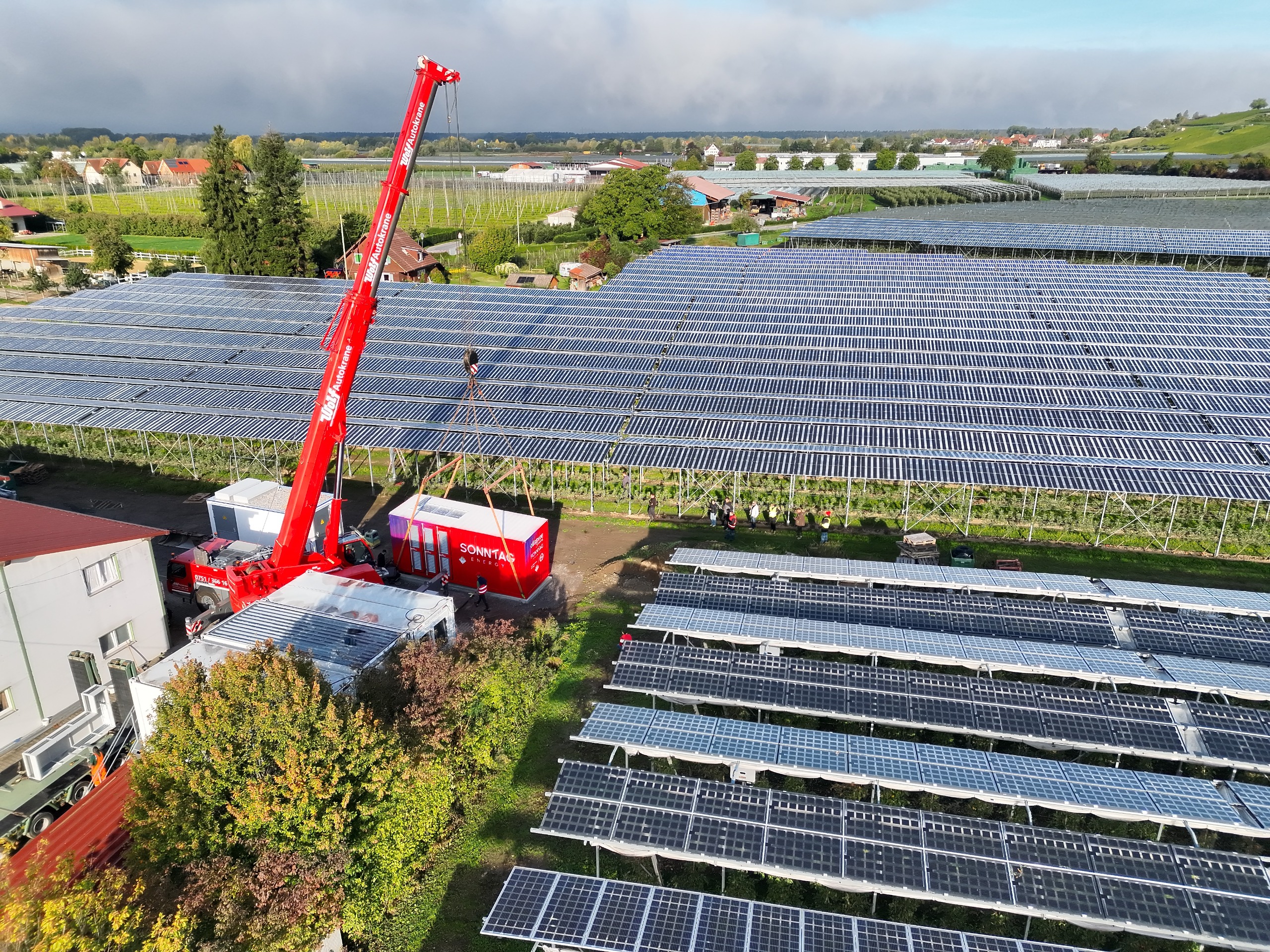 Lieferkran mit Batteriespeicher in einer Agri-PV-Anlage.